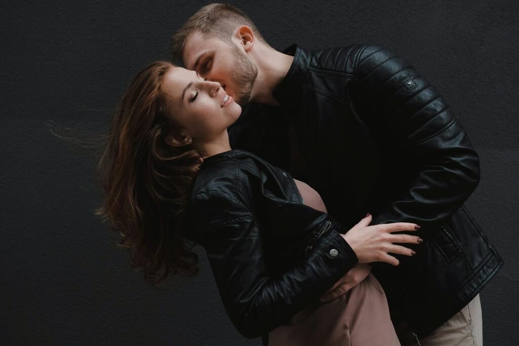 Young couple enjoying a romantic moment in stylish leather jackets. Modern and passionate vibe.