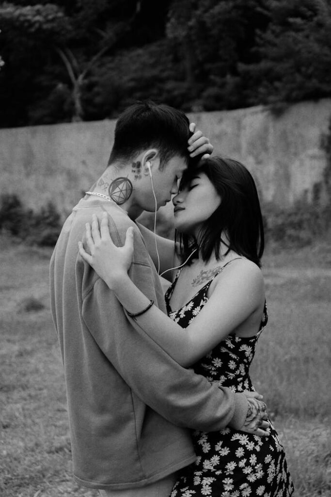 A young couple shares a tender embrace while listening to music outdoors in Indonesia.